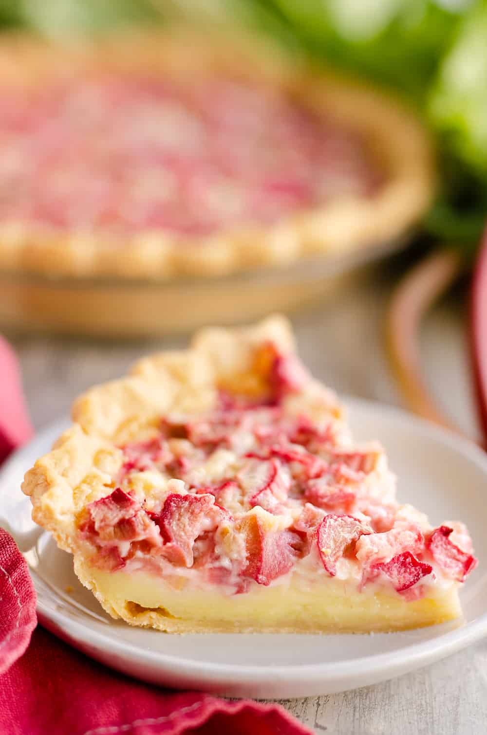 slice of rhubarb custard pie on a white plate.