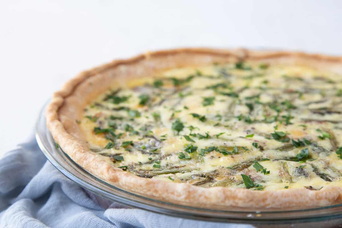 whole asparagus quiche in a glass pie dish.