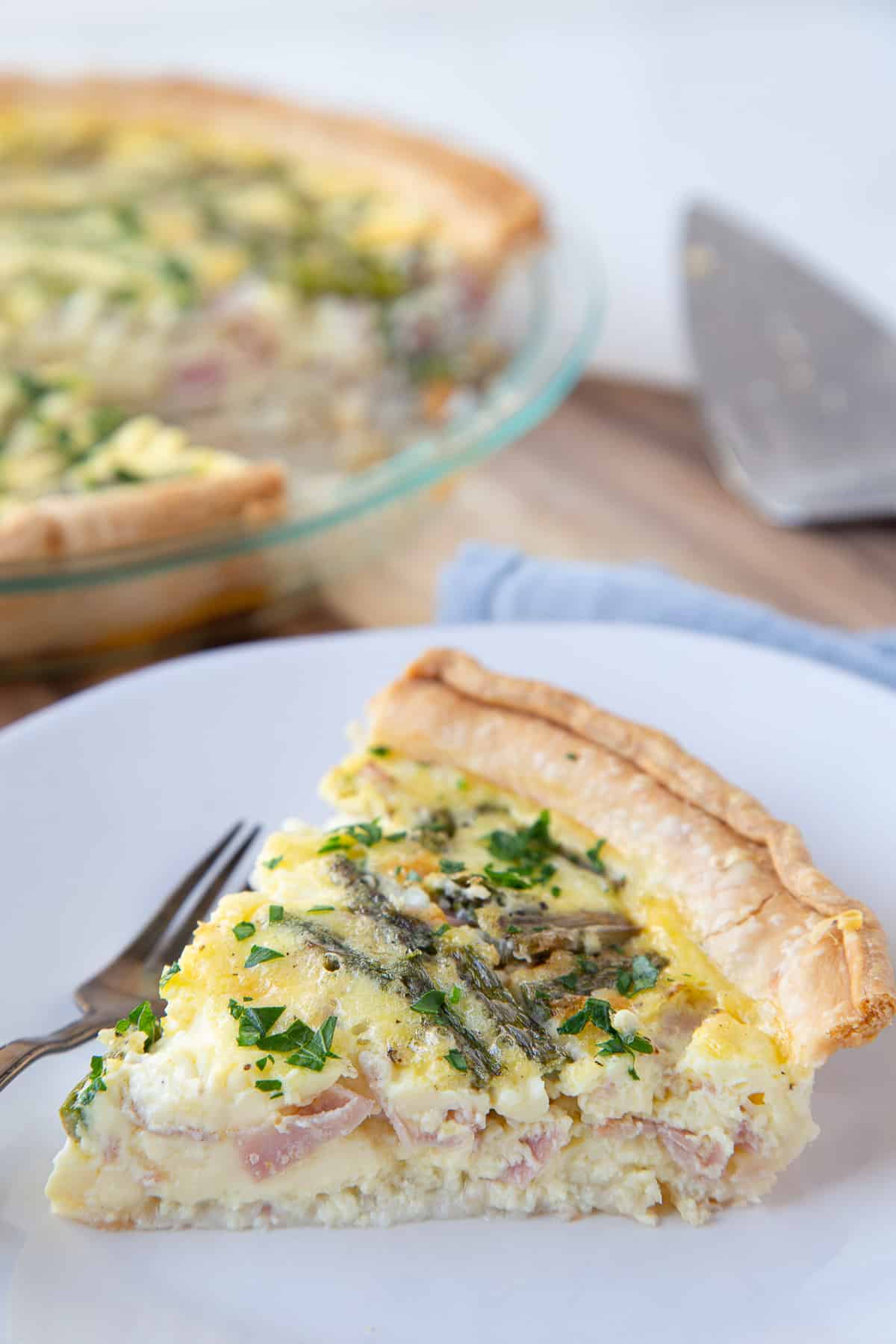 slice of asparagus quiche on a white plate.