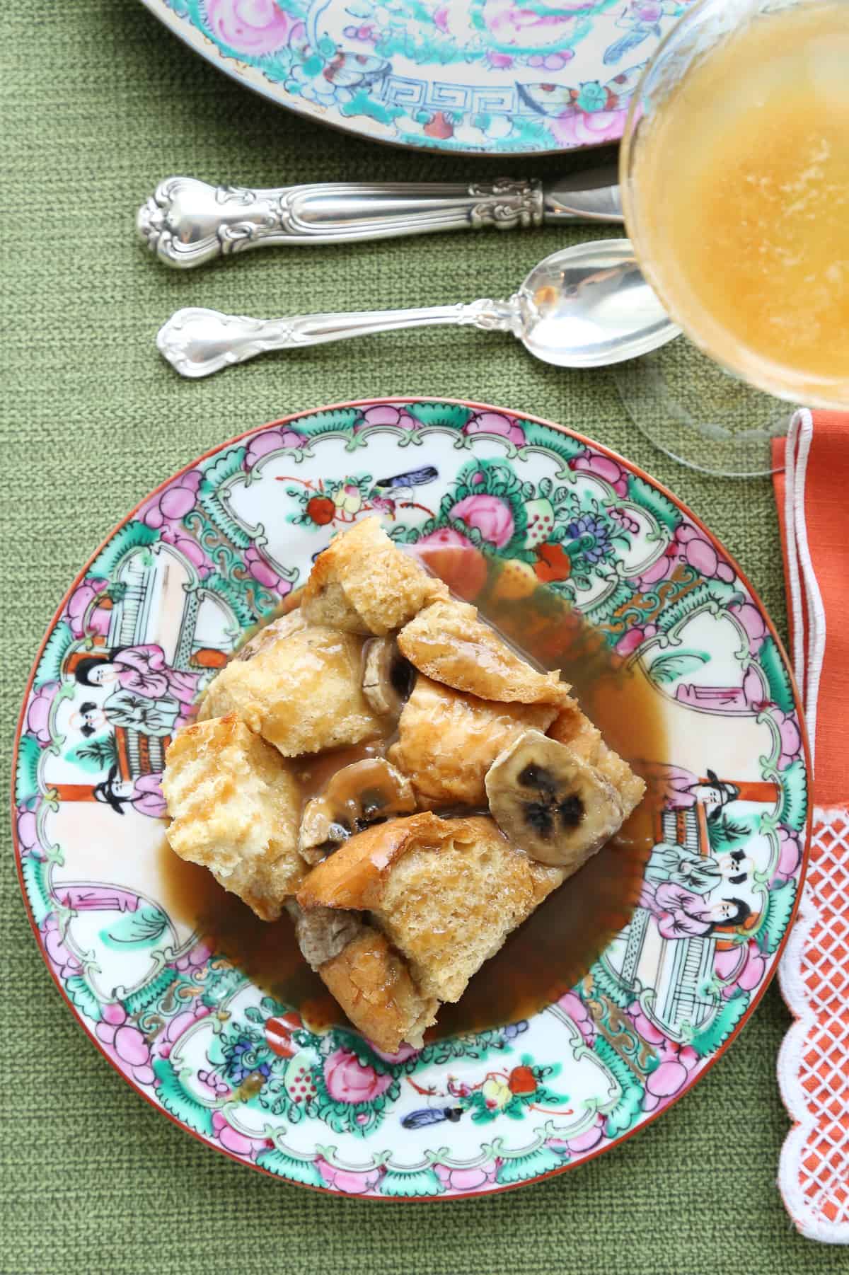 slice of banana bread french toast casserole on a colorful china plate.