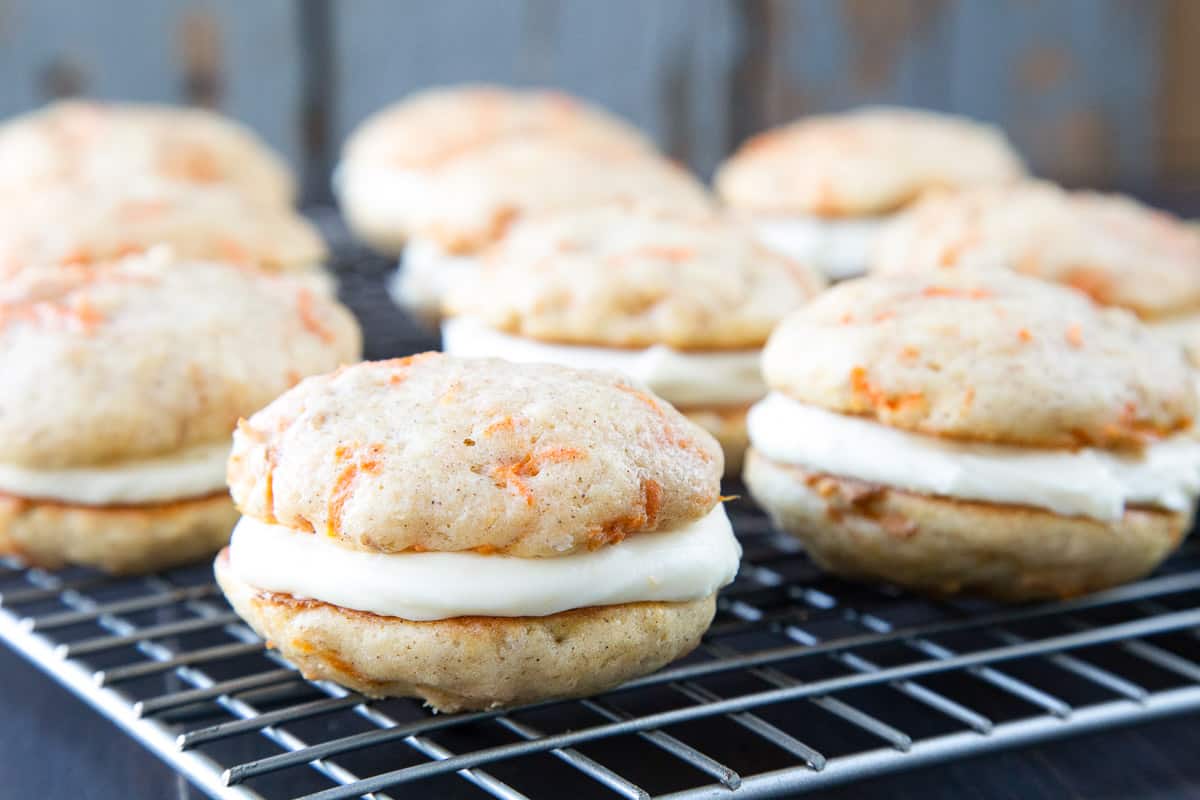 carrot cake whoopie pies on a wire rack.
