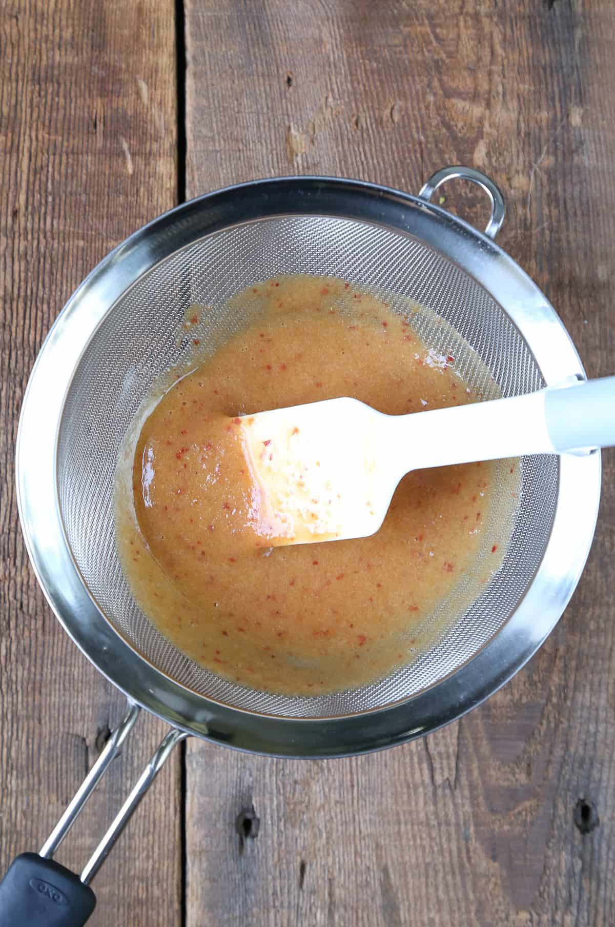 peach and apricot puree in a colander.