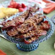 blue glass pedestal platter with praline bacon on top.