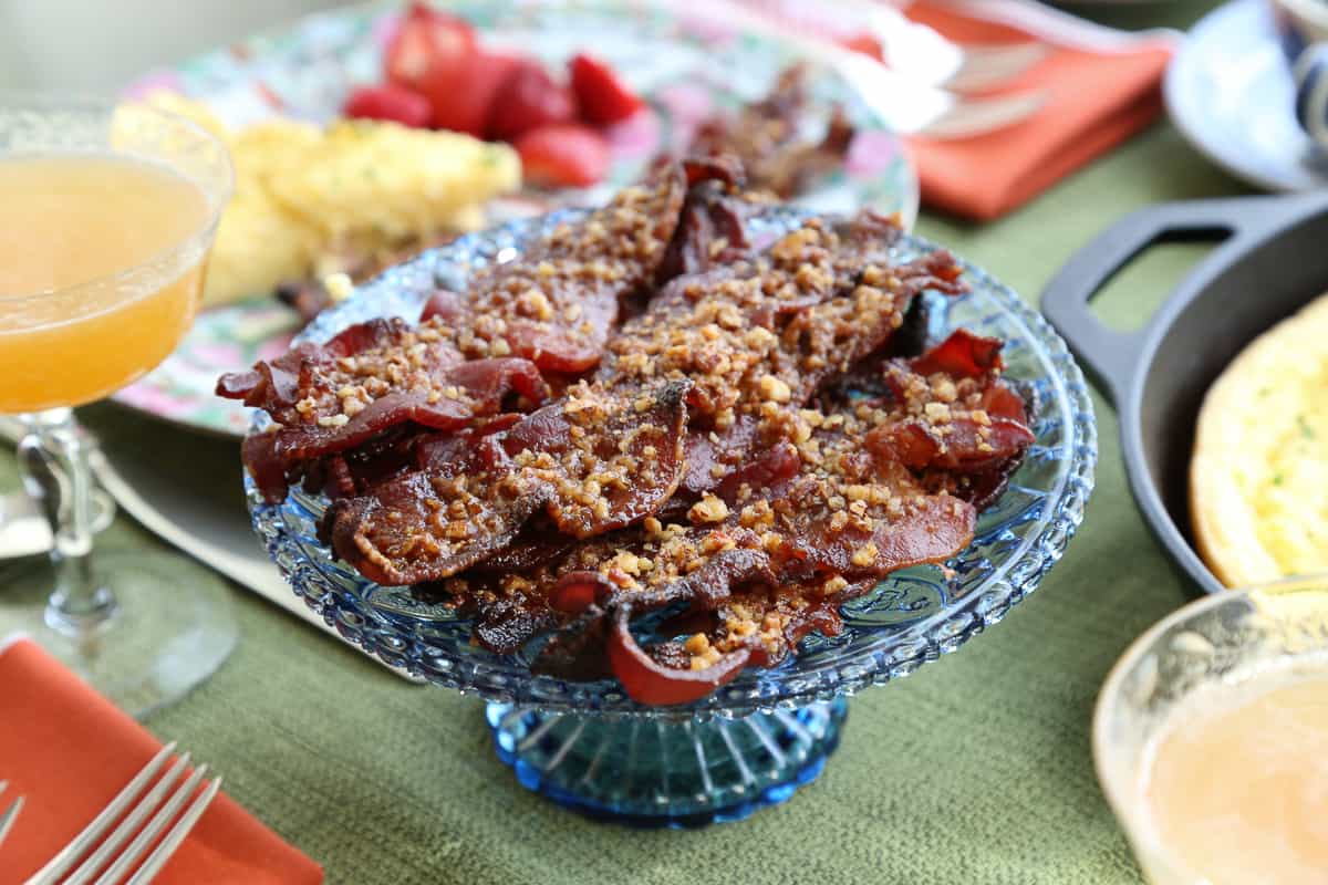 blue glass pedestal platter with praline candied bacon on top.