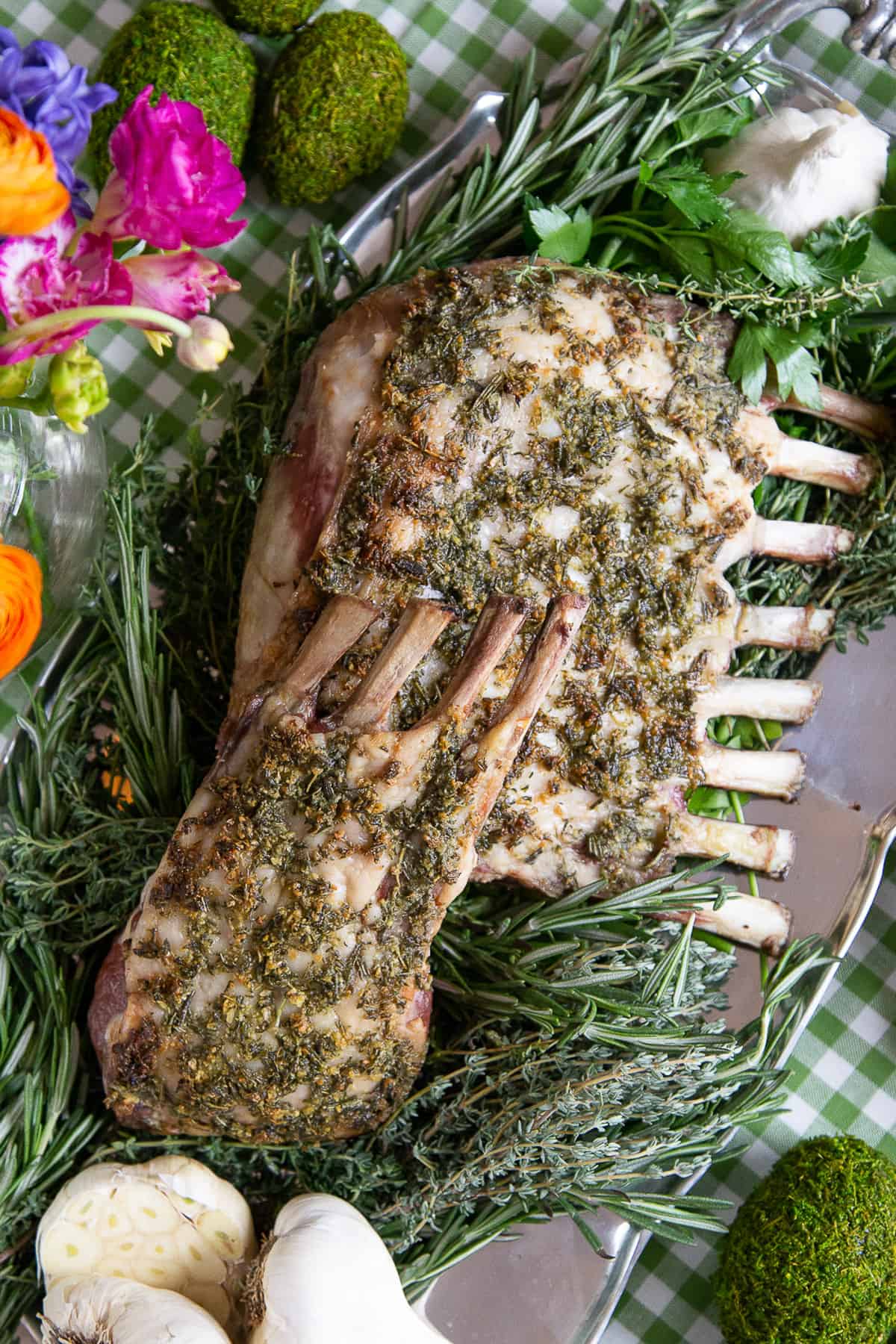rack of lamb on a bed of fresh herbs and garlic.