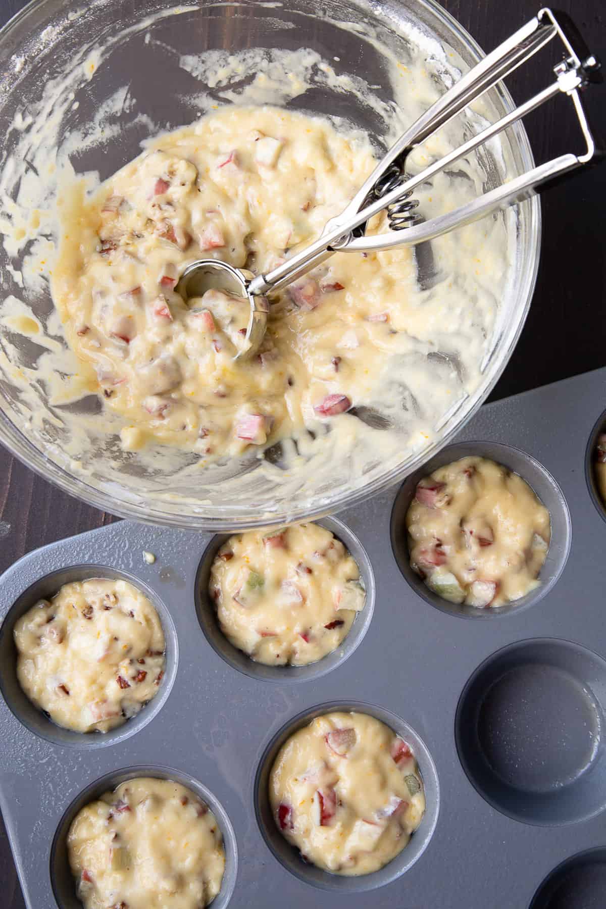 rhubarb muffin batter in a bowl and in muffin cups.