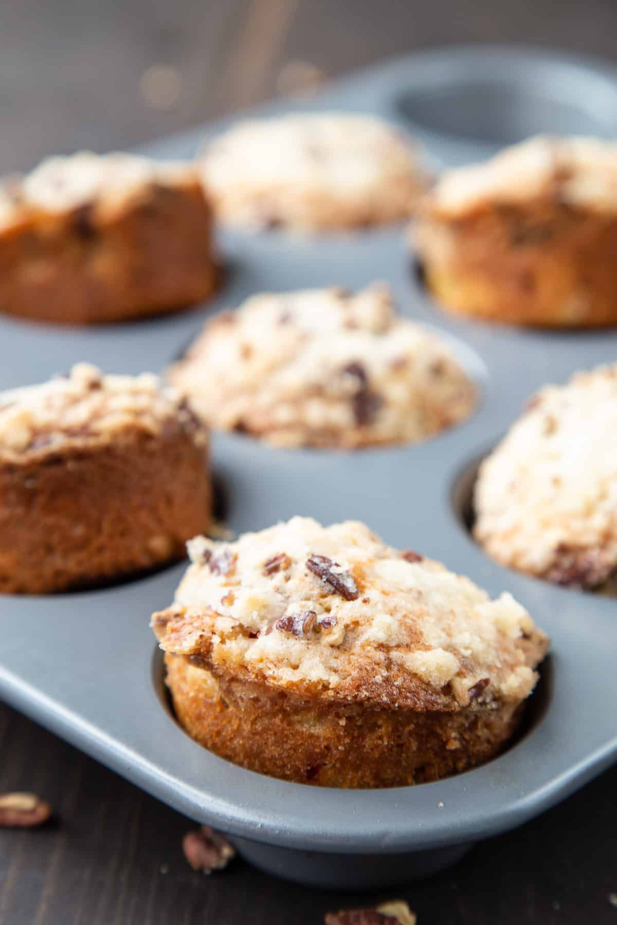 rhubarb muffins popping out of a muffin tin.