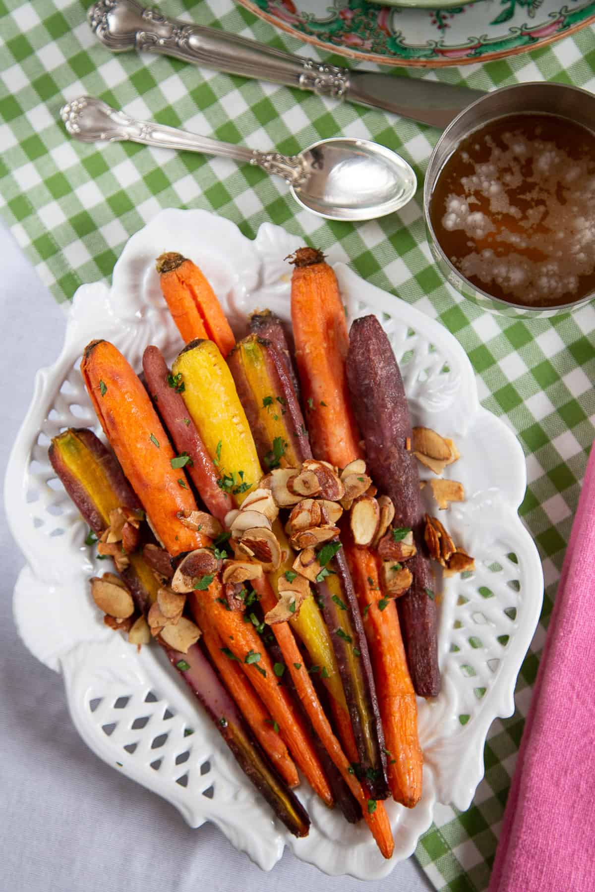 brown sugar glazed carrots topped with sliced almonds on a white platter.