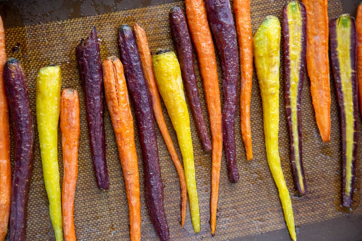 cooked rainbow carrots on a sheet pan.