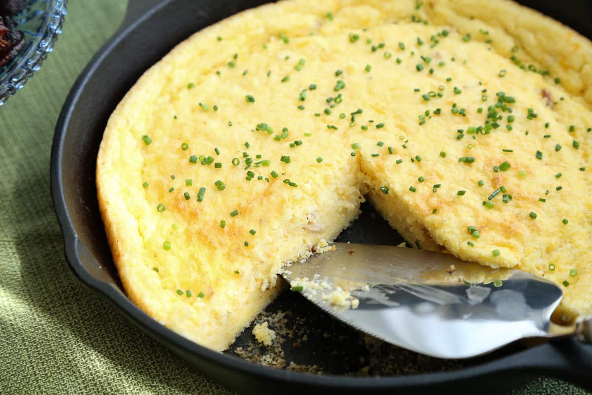 spoon bread with slice taken out with a metal spatula.