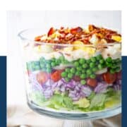 7 layer salad in a glass trifle dish.
