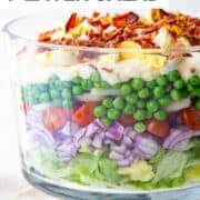 7 layer salad in a glass trifle dish.