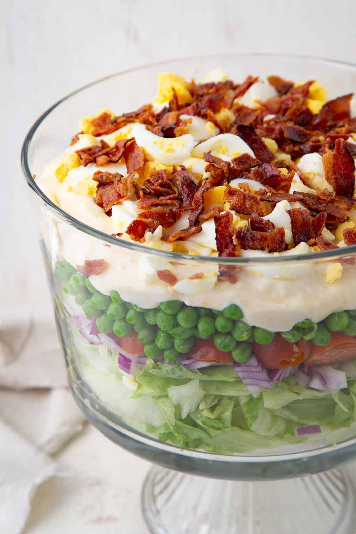 original 7 layer salad layered in a glass trifle dish.