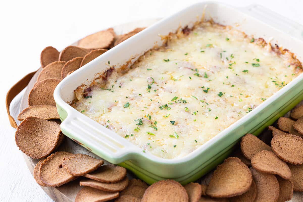 reuben dip in a casserole dish surrounded by rye chips.