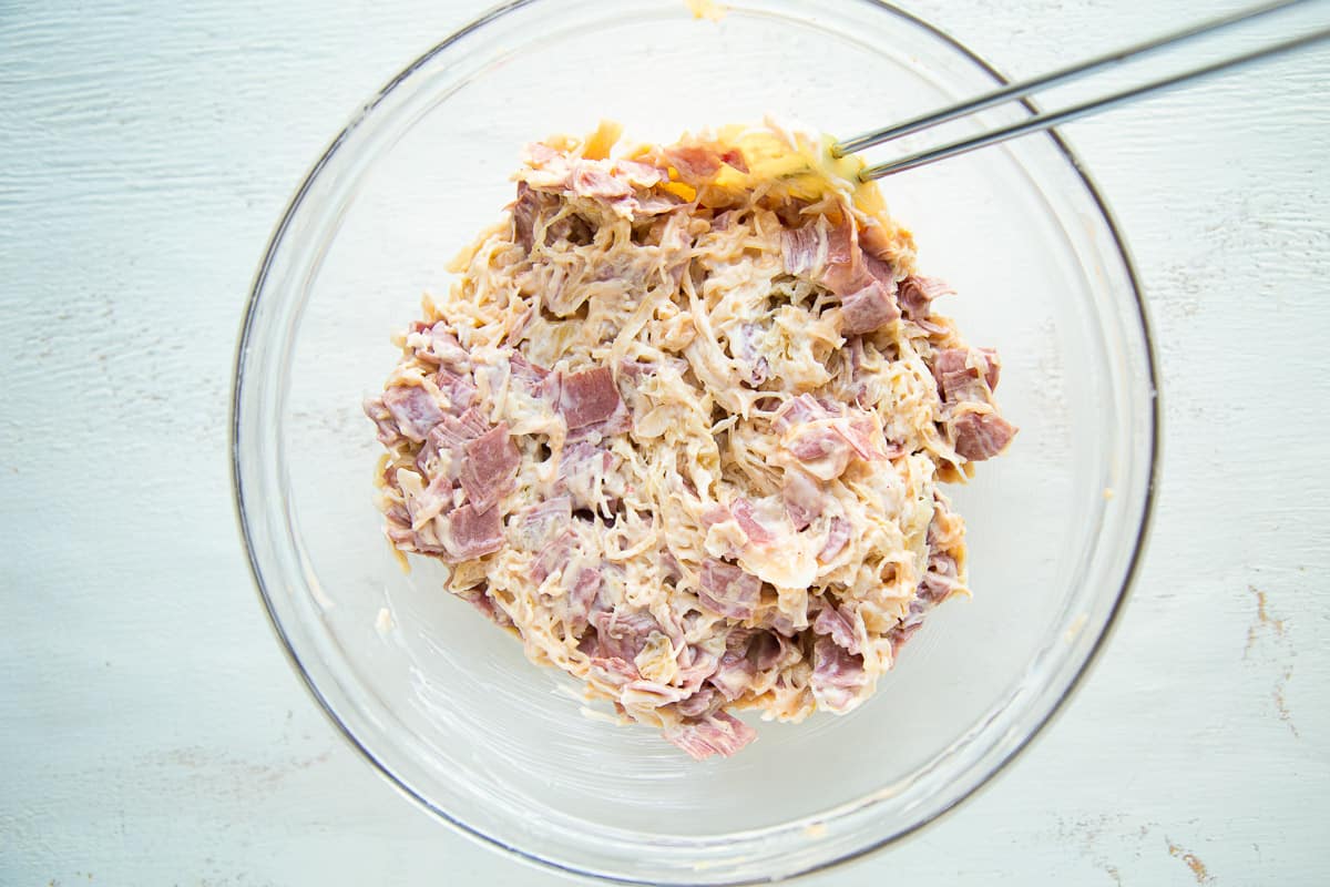 corned beef and swiss cheese in a glass mixing bowl.