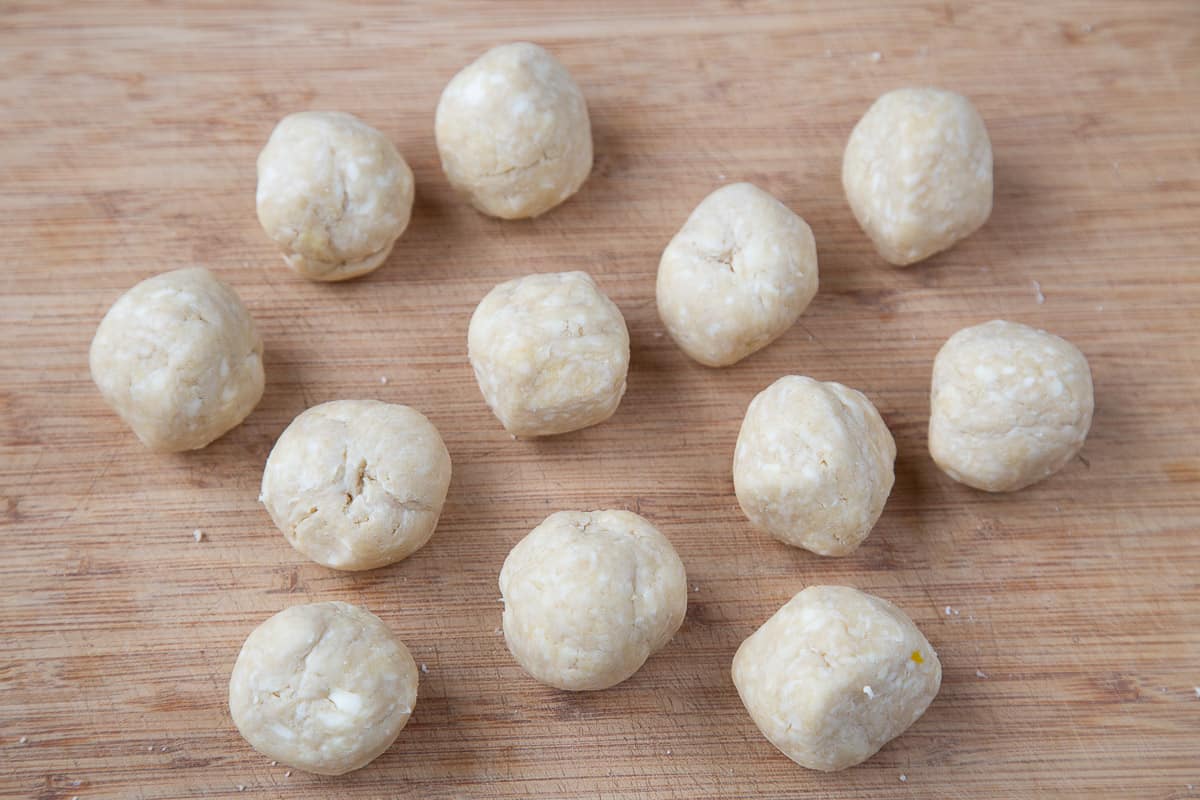 balls of empanada dough on a cutting board.