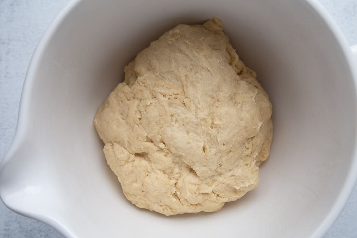 potato roll dough in a white bowl.
