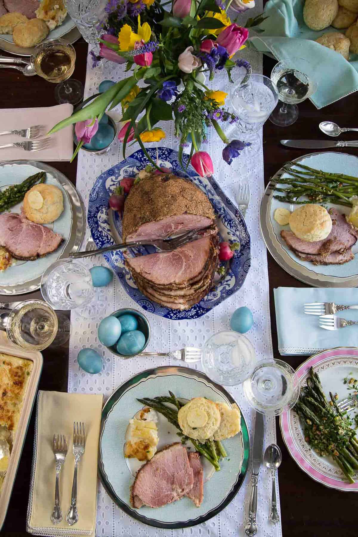 table set for easter dinner with a ham and sides.