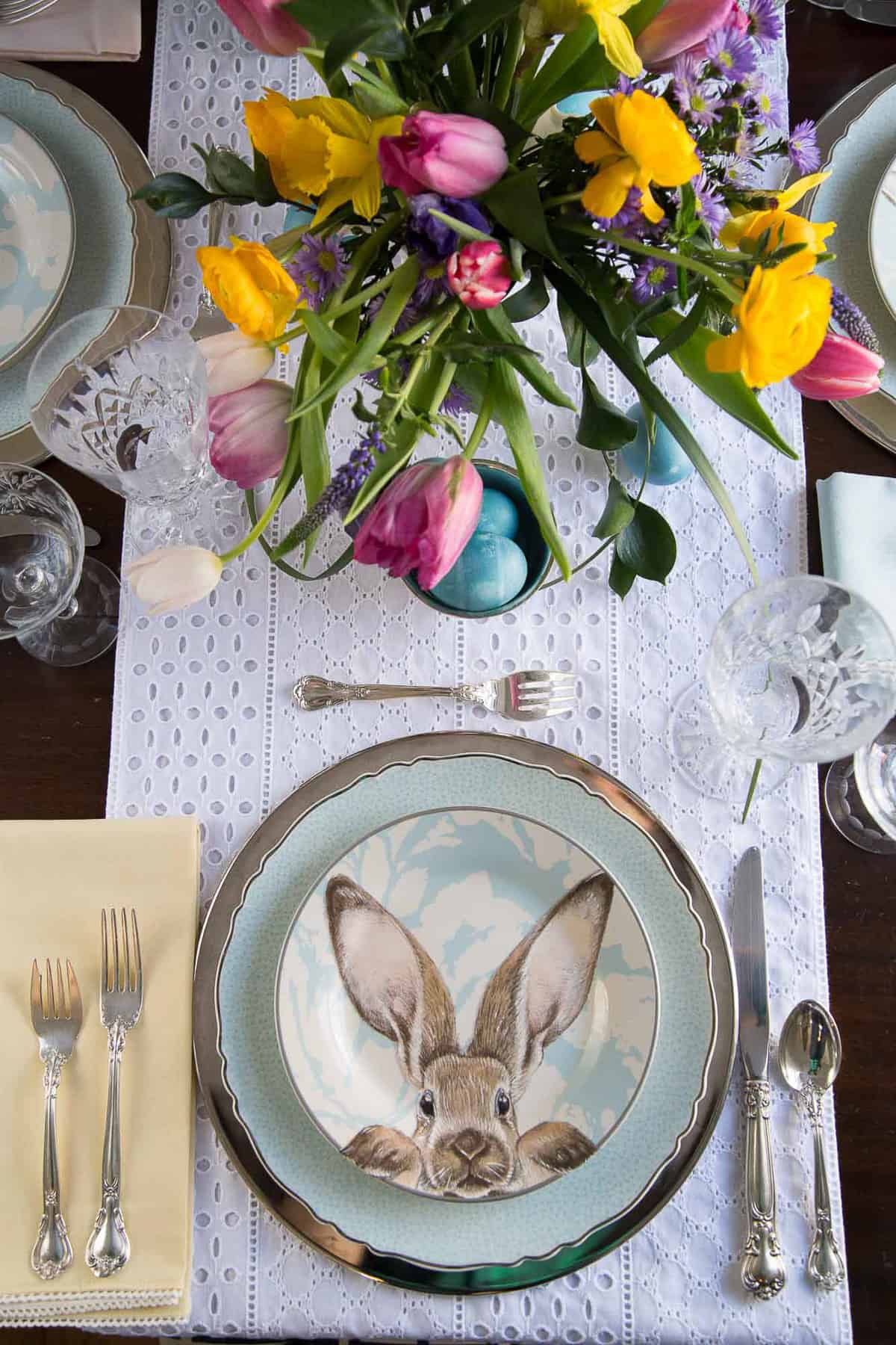 easter dinner table with a bunny plate, silverware, and fresh tulips.