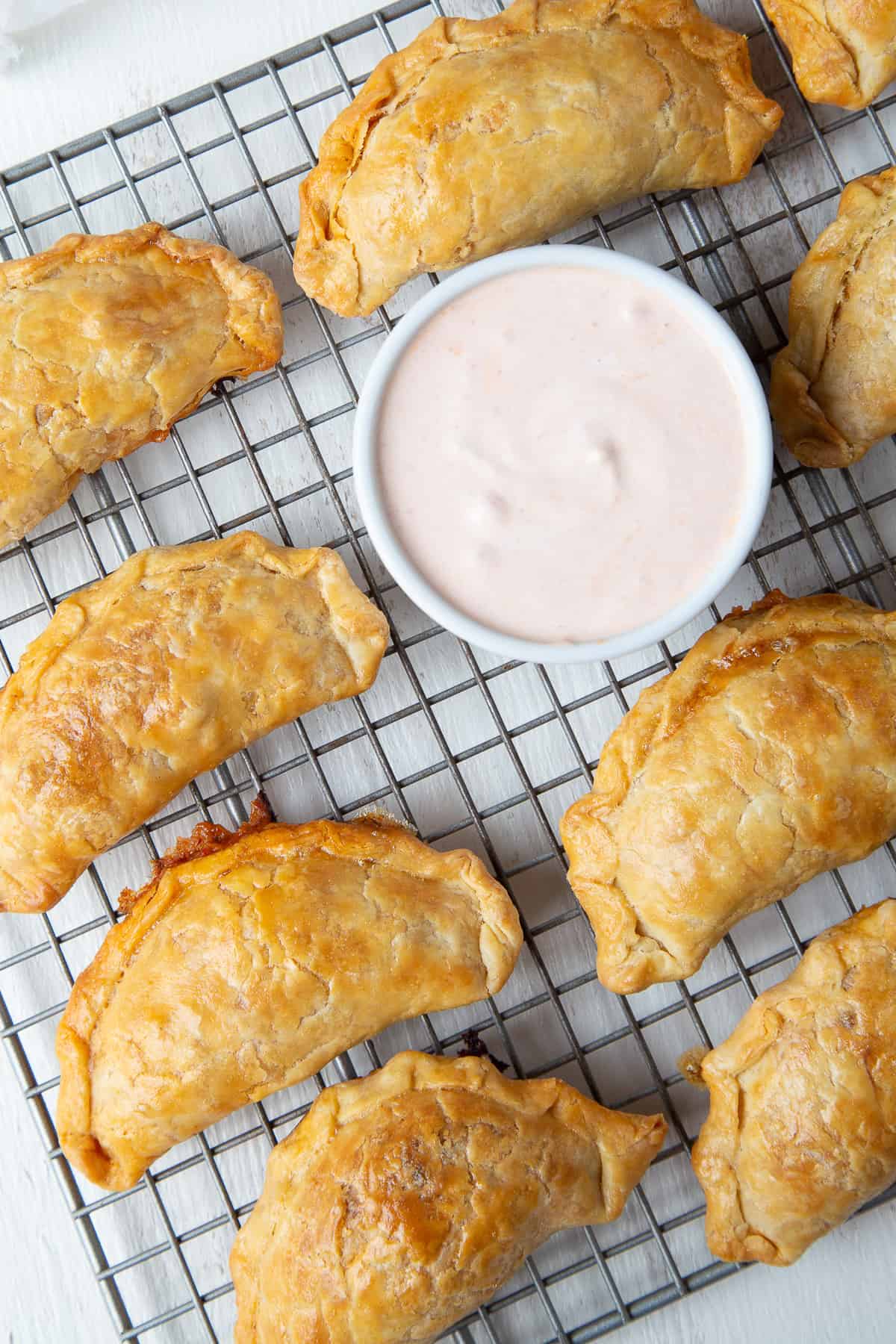 baked empanadas on a wire rack.