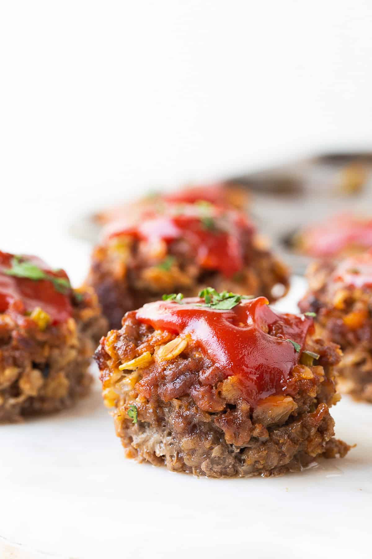 mini meatloaves in the shape of muffins, topped with ketchup.