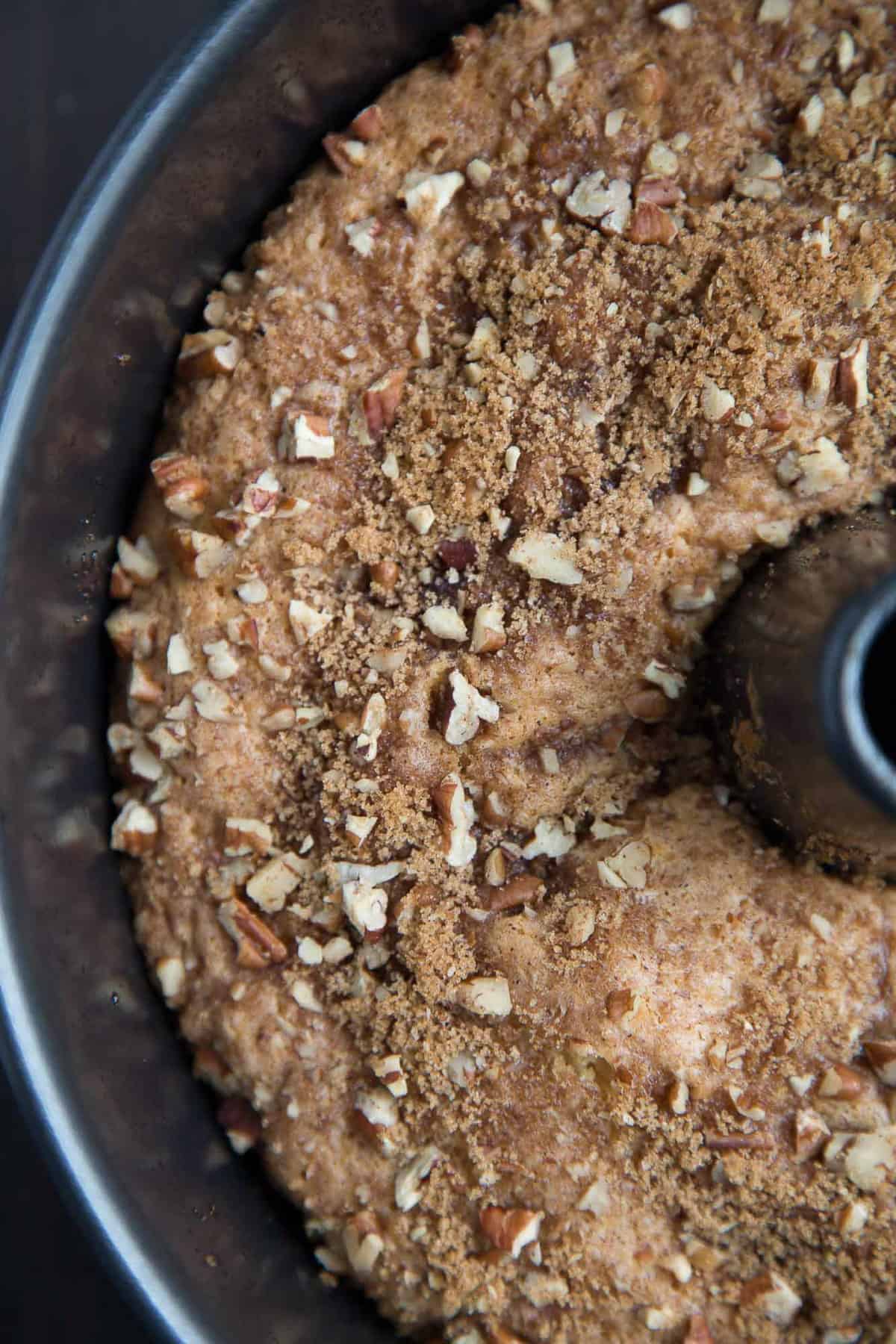 cooked coffee cake topped with pecans in an angel food cake pan.