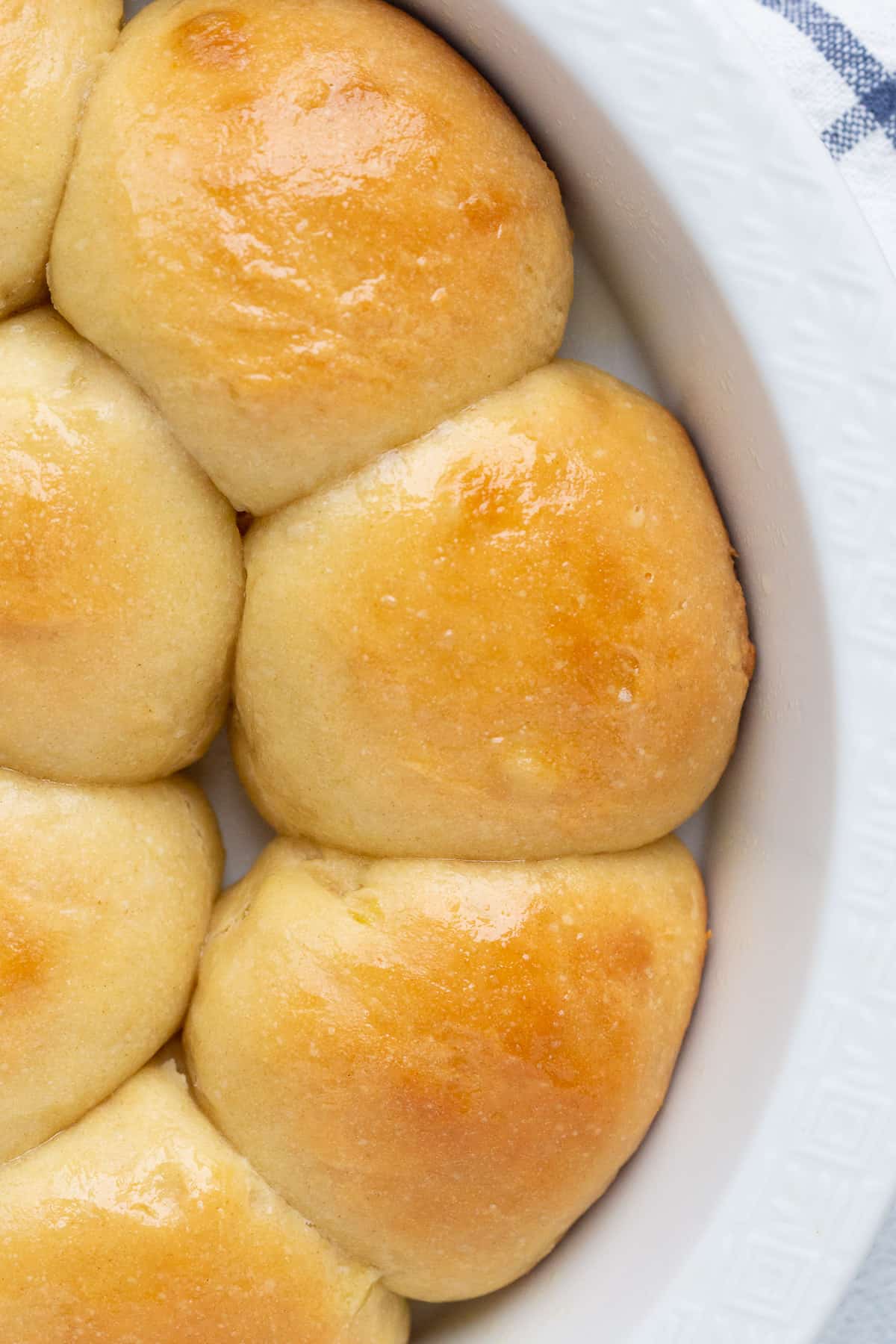 homemade potato rolls in a round white dish.