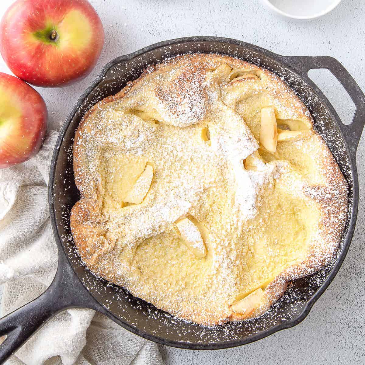 german pancake with apples in cast iron skillet.