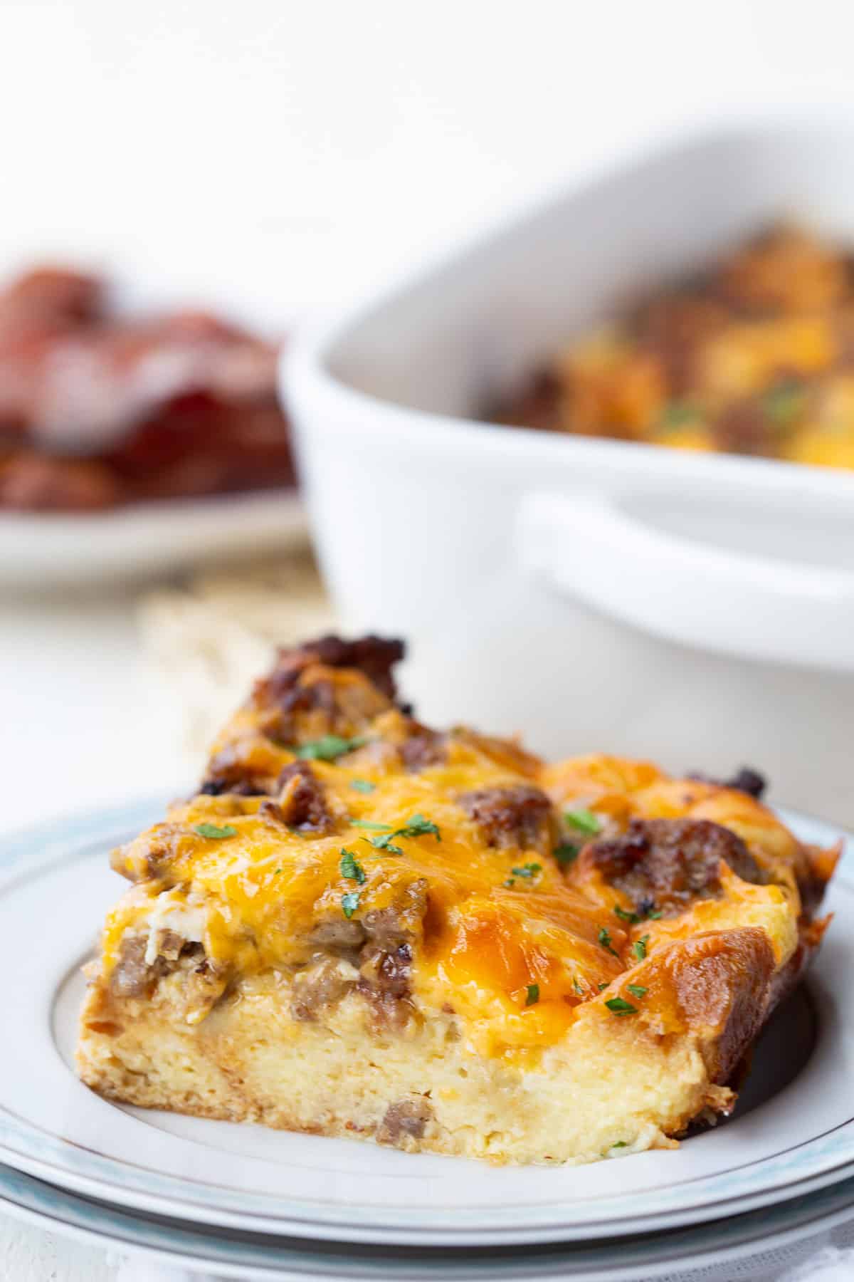 slice of sausage and egg casserole on a white plate.