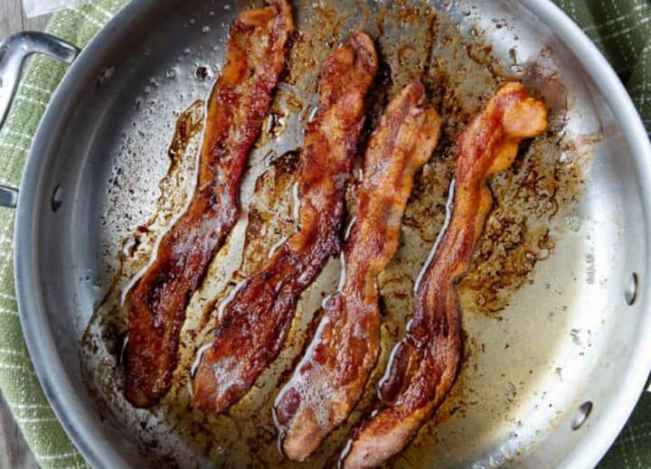 4 strips of bacon in a skillet.