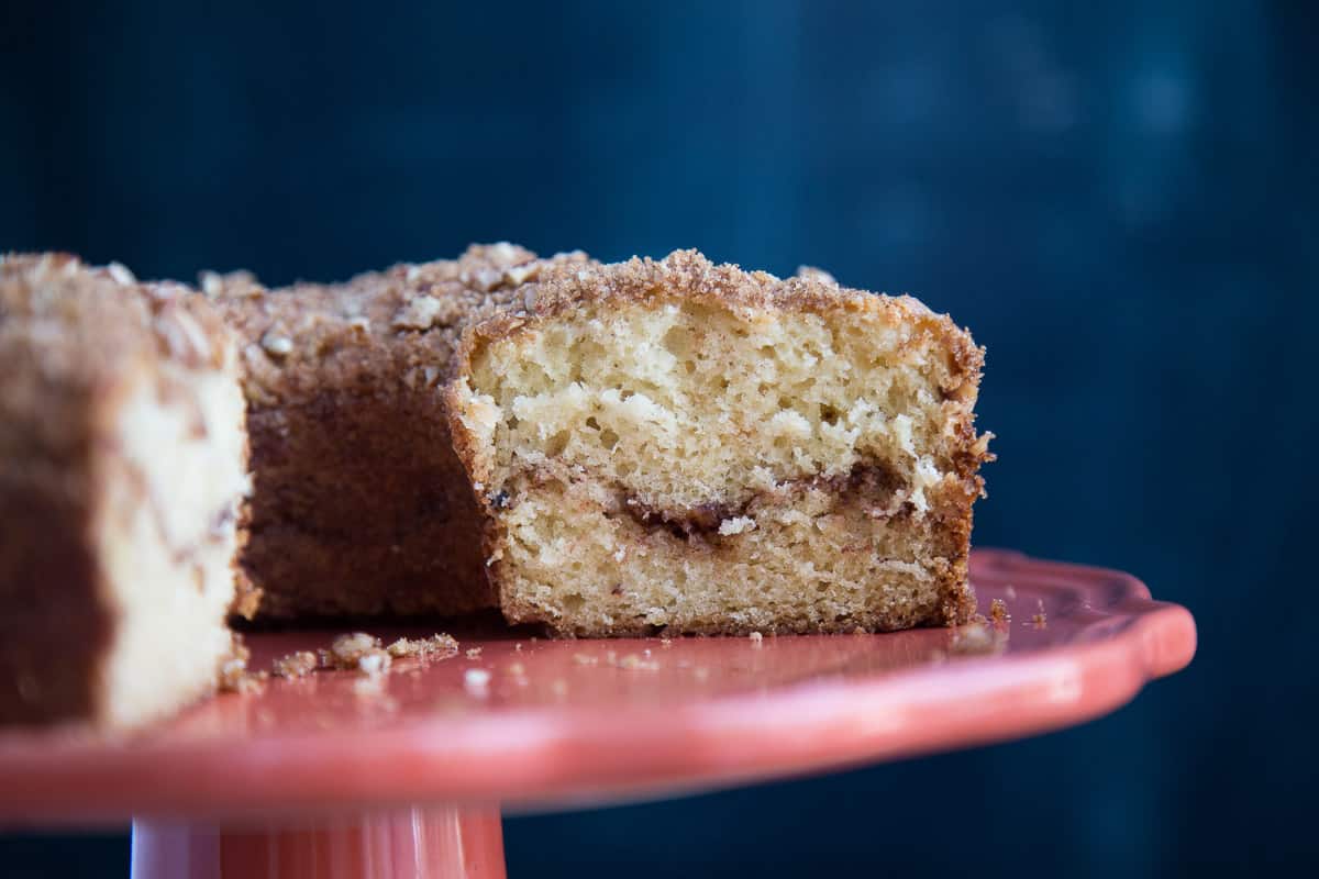 sour cream coffee cake on a pink cake pedestal.