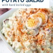 red potato salad topped with paprika and hard boiled eggs.