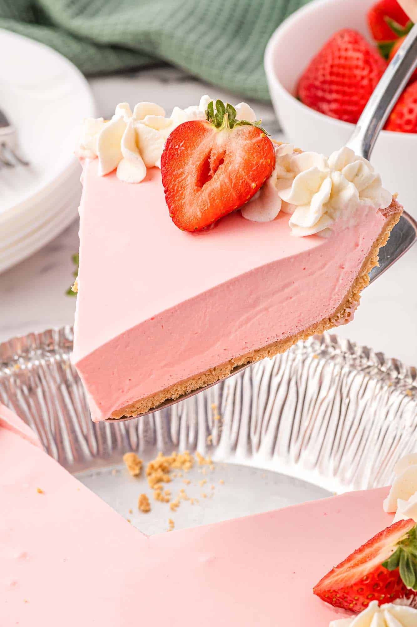 slice of no bake strawberry pie being lifted out of a pie dish.