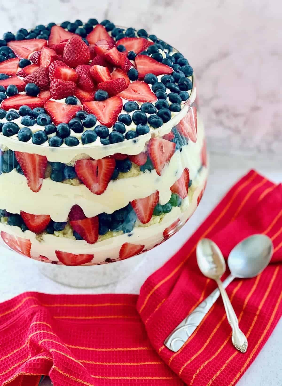 trifle dish filled with pudding and berries.