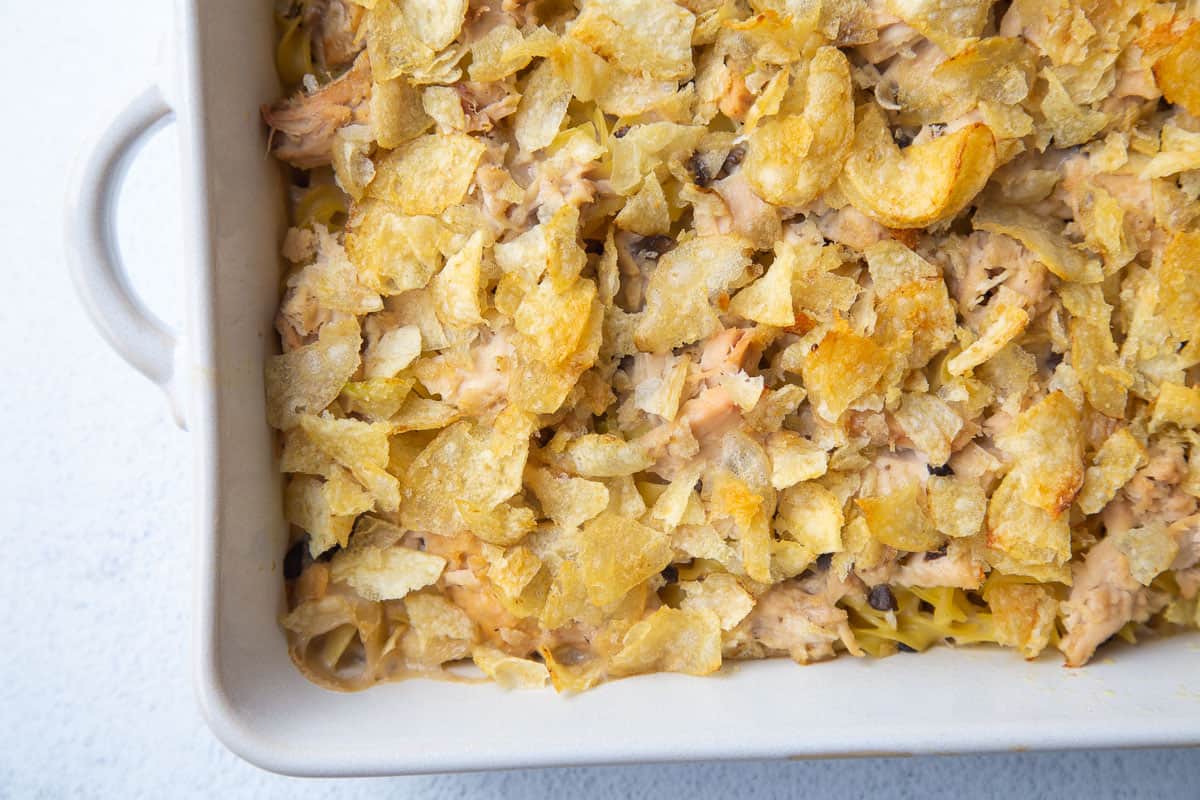 tuna noodle casserole with potato chips in a white dish.