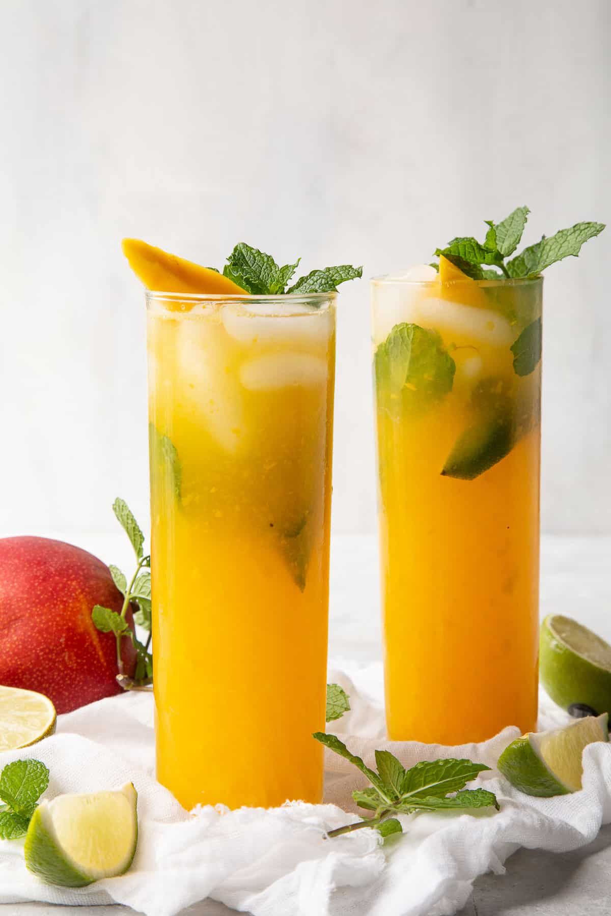 two mango mojitos garnished with mint.