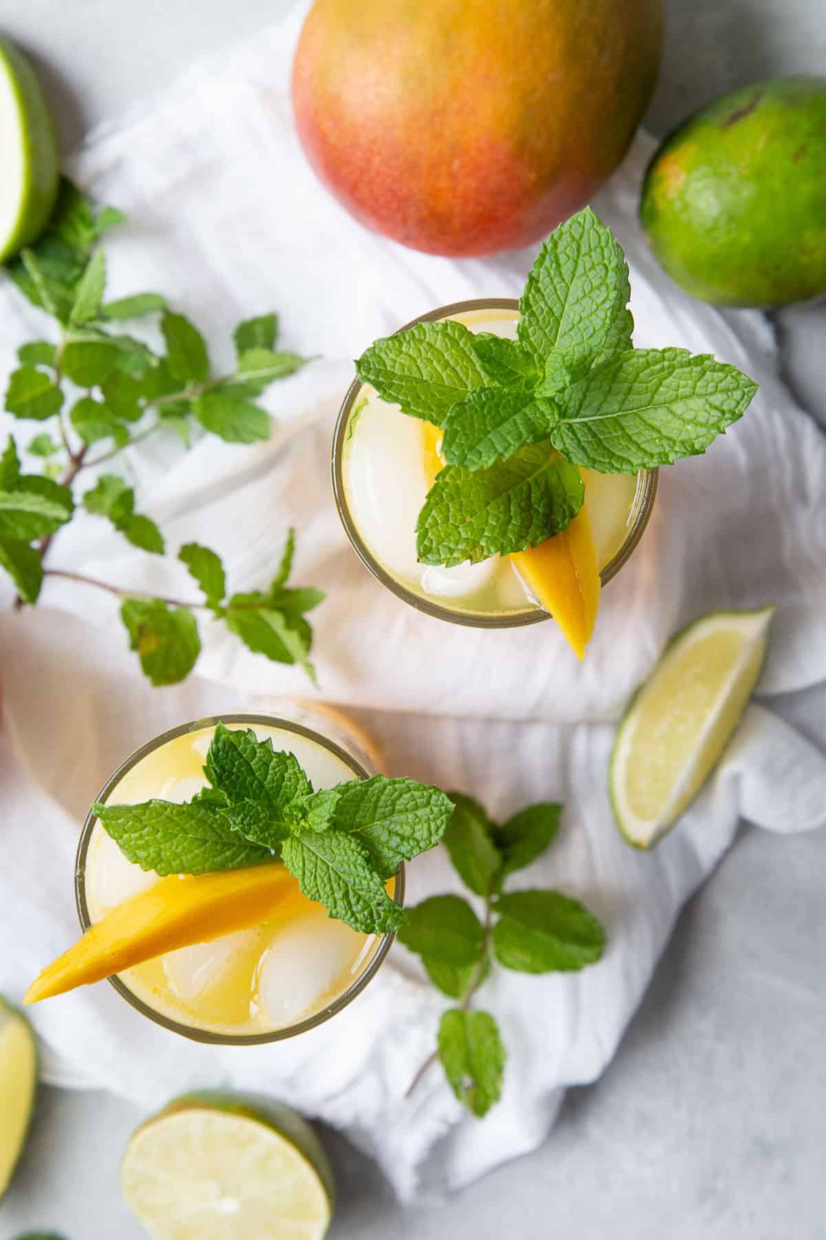 mango mojitos topped with mango slices and fresh mint.