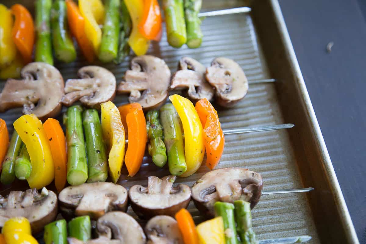 mushrooms, bell peppers, and asparagus on metal skewers.