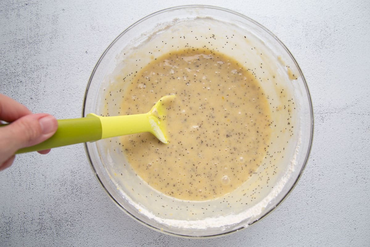 batter with poppy seeds in a glass bowl.