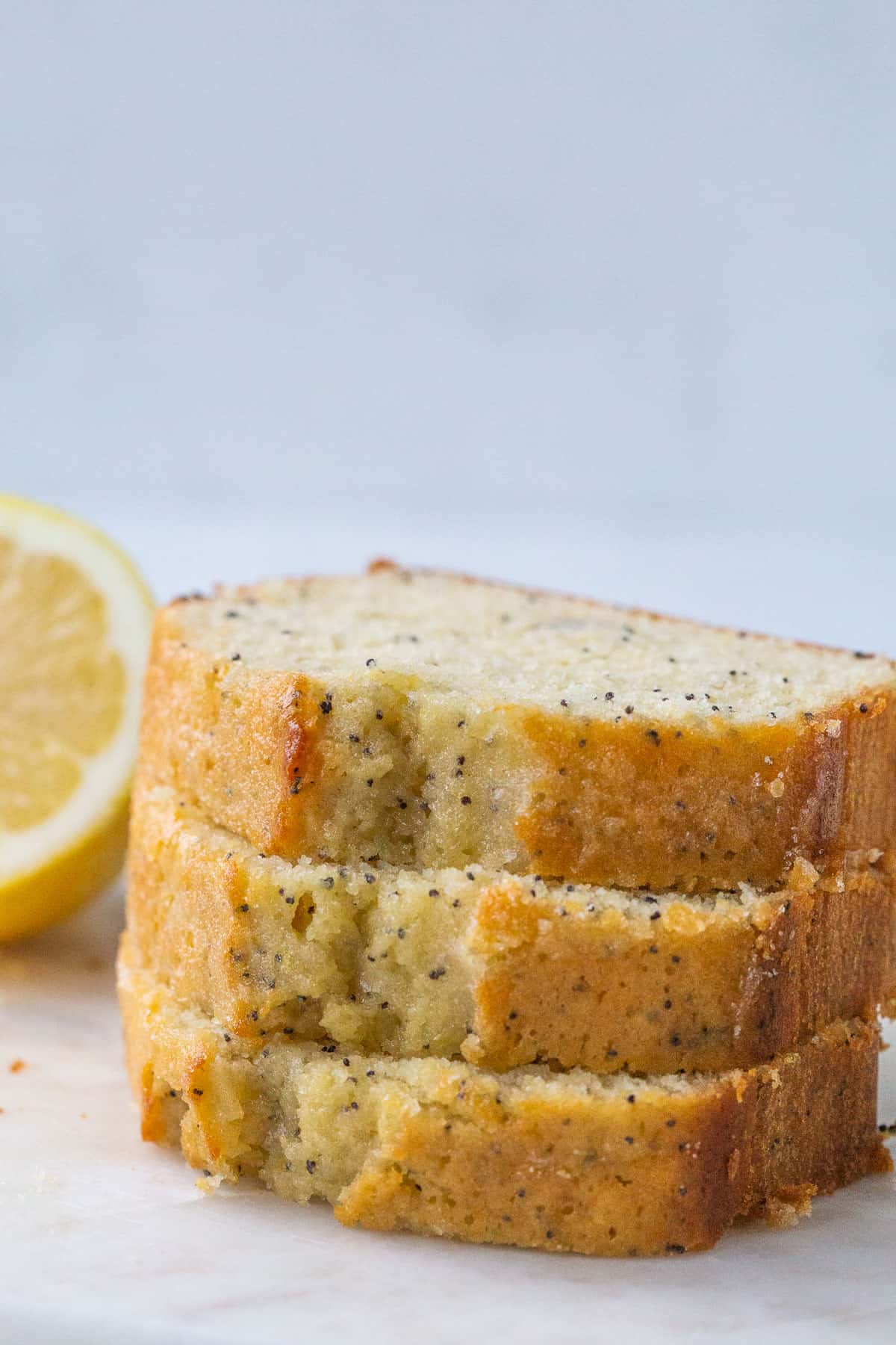 three slices of lemon poppy seed bread stacked up.