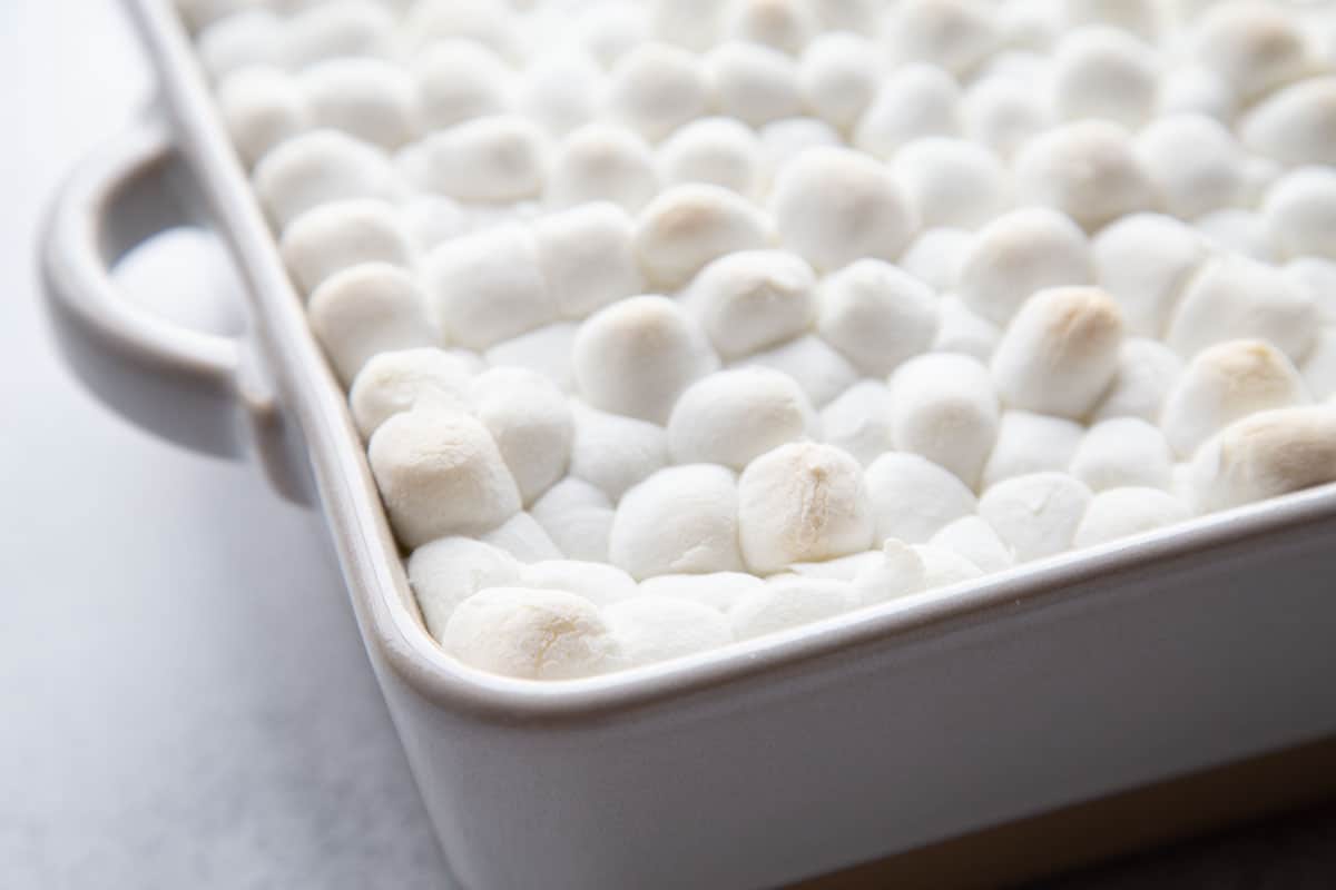 layer of toasted marshmallows in a white casserole dish.