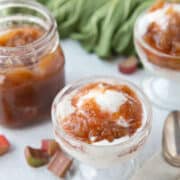 rhubarb sauce in a jar next to parfait glasses with ice cream and rhubarb sauce.