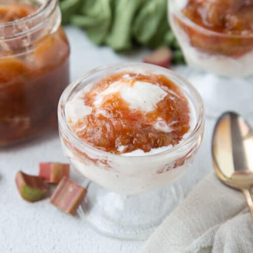 rhubarb sauce over ice cream in a glass parfait dish.