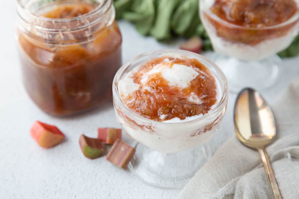 rhubarb sauce topped ice cream in a parfait dish.