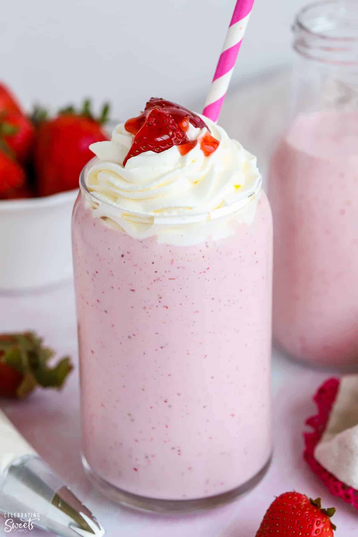 strawberry milkshake topped with whipped cream.