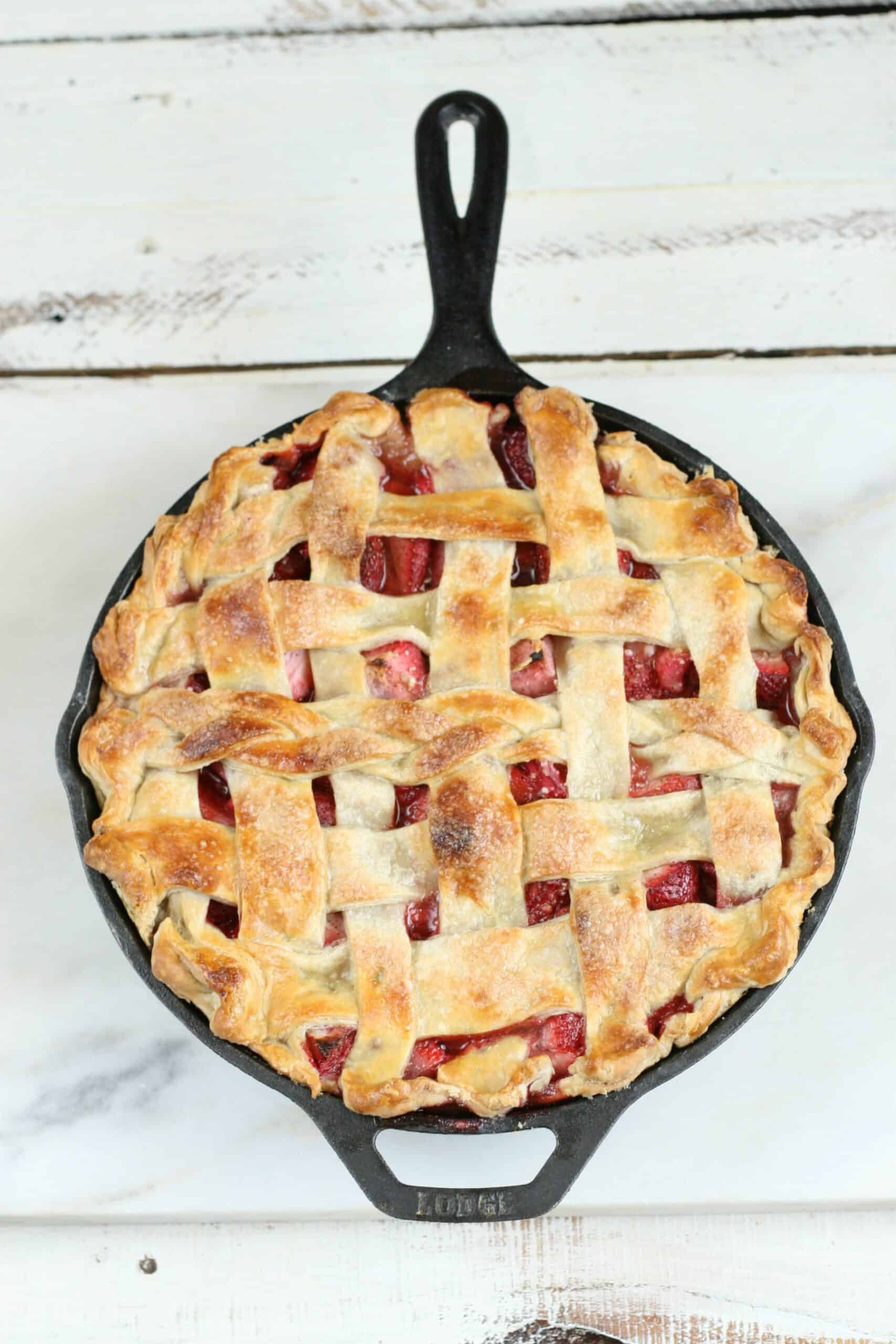 strawberry pie with lattice crust in a cast iron pan.