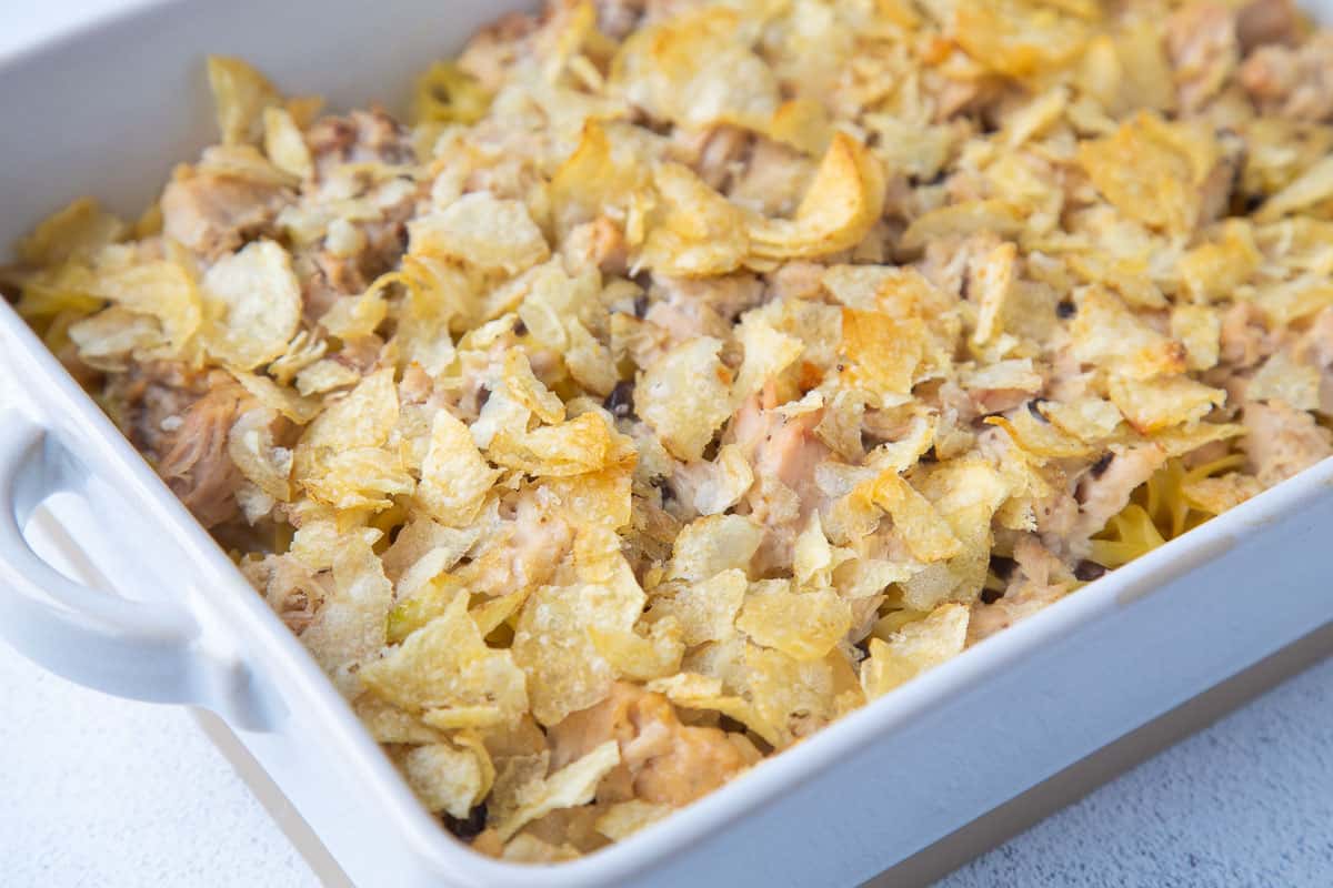 tuna noodle casserole topped with potato chips in a casserole dish.