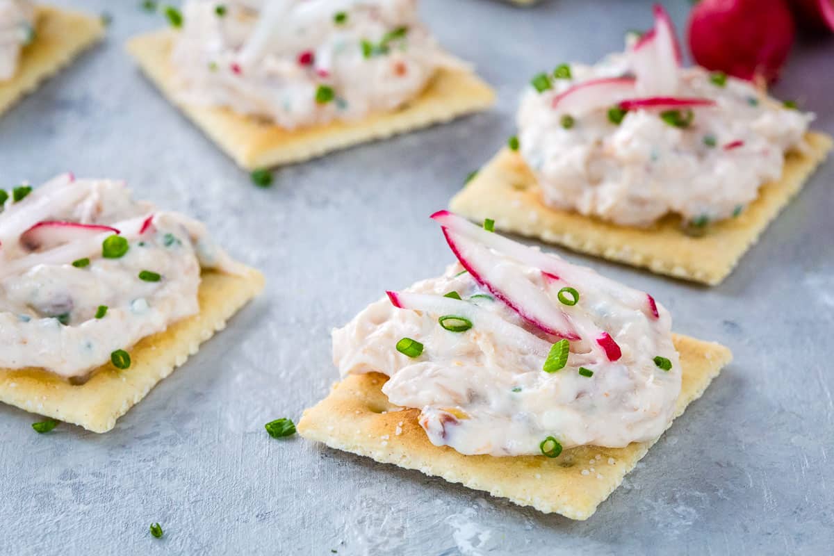 crab dip on saltines on a gray background.