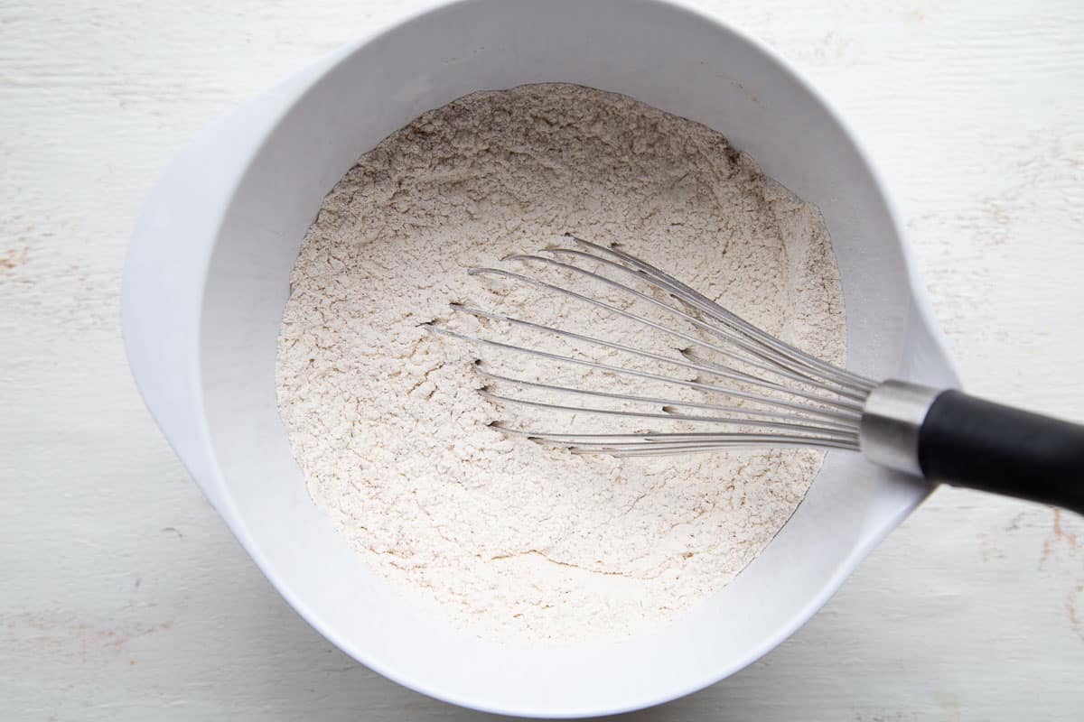 flour in a white bowl with a whisk.