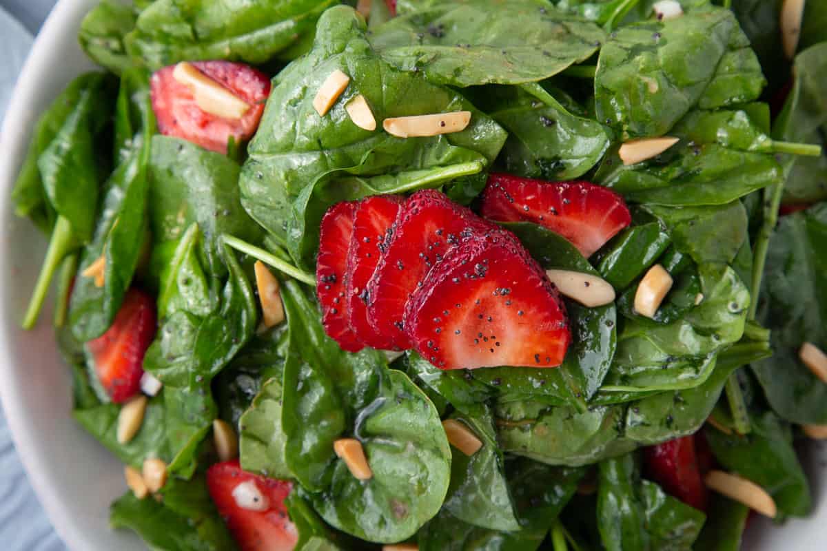 baby spinach with sliced strawberries.